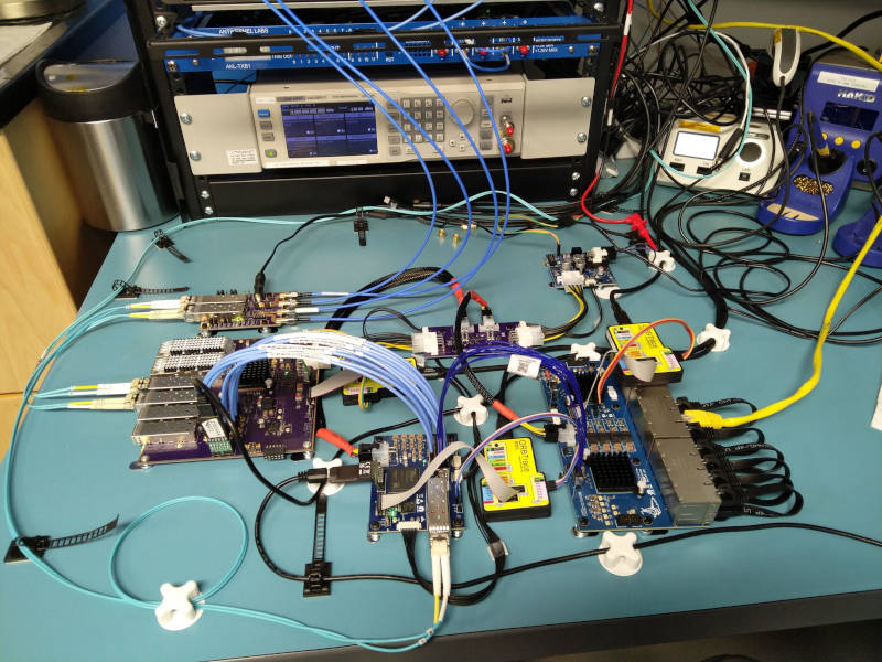Bench setup with the line card, power supply, and FPGA dev board cabled together