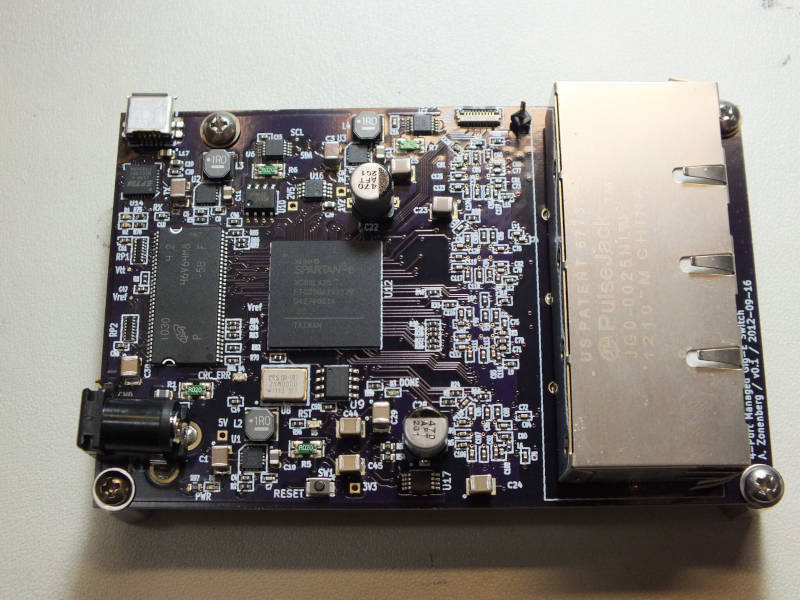Dark purple PCB with a mini USB port, quad RJ45, and Spartan-6 FPGA on it